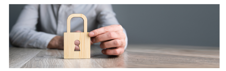 Une personne qui tient dans ses mains un cadenas en bois