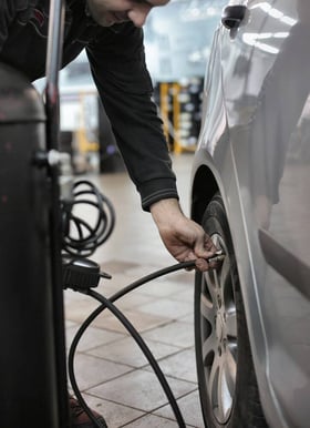 Technicien qui contrôle la pression des pneus